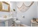 Stylish powder room with a pedestal sink, decorative mirror, and coastal-themed decorations at 1296 Foxtail Dr., Longs, SC 29568