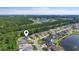Aerial shot of homes in a lush, green neighborhood with a community lake and mature trees, showcasing the location at 205 Waterfall Circle, Little River, SC 29566