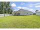 Spacious backyard with green grass and a white brick house with a covered patio, perfect for outdoor enjoyment at 205 Waterfall Circle, Little River, SC 29566