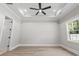 Spacious bedroom features a tray ceiling, ceiling fan, and large window at 205 Waterfall Circle, Little River, SC 29566