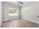 Bright bedroom with sleek ceiling fan, large window, and light wood floors at 205 Waterfall Circle, Little River, SC 29566