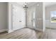 Bright foyer featuring wood flooring, closet, elegant lighting, and front door with window at 205 Waterfall Circle, Little River, SC 29566