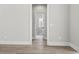 Hallway with door leading to bathroom featuring wood floor, base molding, and neutral walls at 205 Waterfall Circle, Little River, SC 29566