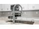 Close up view of a stainless steel kitchen sink and faucet with white cabinets at 205 Waterfall Circle, Little River, SC 29566