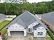 Aerial view of a home under construction with protective wrap, showcasing the roof and garage at 269 Waterfall Circle, Little River, SC 29566