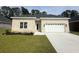 Charming single-story home boasts a brick facade, well-manicured lawn, and an attached two-car garage at 293 Waterfall Circle, Little River, SC 29566