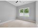 Bright, empty bedroom features a ceiling fan and a sunlit window at 297 Waterfall Circle, Little River, SC 29566