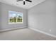 This airy bedroom includes a ceiling fan, neutral walls, and a large window framing a scenic outdoor view at 297 Waterfall Circle, Little River, SC 29566