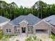 Newly constructed brick home with a two-car garage, large windows, and a welcoming front entrance at 297 Waterfall Circle, Little River, SC 29566