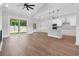 Open concept kitchen and living area featuring hardwood floors, white cabinets, modern appliances, and a sliding glass door at 297 Waterfall Circle, Little River, SC 29566
