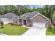 Beautiful brick home with an attached two-car garage and lush green lawn at 309 Waterfall Circle, Little River, SC 29566