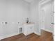 A simple, functional laundry room with modern amenities and wooden floors at 309 Waterfall Circle, Little River, SC 29566