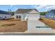 Beautiful new home with a large driveway, manicured lawn and a light blue front door at 329 Palmetto Sand Loop, Conway, SC 29527