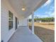 Covered patio with ceiling fans overlooks a spacious backyard with views of the community pond at 329 Palmetto Sand Loop, Conway, SC 29527