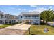 Elevated beach home with light blue siding, a deck, and a spacious driveway at 319 36Th Ave. N, North Myrtle Beach, SC 29582