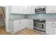 Clean kitchen view showing stainless steel oven, white cabinets, gray counters, and light blue backsplash at 9048 Abingdon Dr., Myrtle Beach, SC 29579