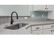 Close up of kitchen sink with gray countertops and white cabinets; modern design at 9048 Abingdon Dr., Myrtle Beach, SC 29579