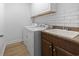 Convenient laundry area with a utility sink, a washer, a dryer, upper cabinets, and subway tile backsplash at 9048 Abingdon Dr., Myrtle Beach, SC 29579