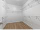 Walk-in closet featuring hardwood floors and white shelving with chrome fixtures at 9048 Abingdon Dr., Myrtle Beach, SC 29579
