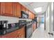 Cozy kitchen with wooden cabinets, black appliances, and an open doorway to the balcony at 1501 S Ocean Blvd. # 240, Myrtle Beach, SC 29577
