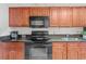Modern kitchen with wooden cabinets, black appliances, and granite countertops at 1501 S Ocean Blvd. # 240, Myrtle Beach, SC 29577