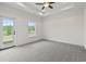 This bedroom features a ceiling fan, a window, a door, light gray carpet, and a trey ceiling at 7913 E Highway 19, Loris, SC 29569