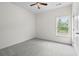 This bedroom features a ceiling fan, a window, light gray carpet, and a door at 7913 E Highway 19, Loris, SC 29569