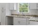 Close-up of a sink in a kitchen with granite countertops and white cabinets at 7913 E Highway 19, Loris, SC 29569