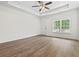Bright living room featuring hardwood floors, large windows, and modern ceiling fan at 7913 E Highway 19, Loris, SC 29569