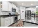 Well-lit kitchen features stainless steel appliances, granite countertops, and white cabinetry at 149 Harmony Ln., Myrtle Beach, SC 29588