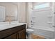Bright bathroom features a white shower-tub combo, wood-look flooring, and a dark vanity with gold fixtures at 5032 Cambria Ct., Little River, SC 29566