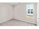Cozy carpeted bedroom with a window bringing in natural light and a door on the right at 5032 Cambria Ct., Little River, SC 29566