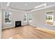 Bright living room with views from many windows, luxury vinyl flooring, and a modern fireplace at 5032 Cambria Ct., Little River, SC 29566