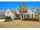 Charming home showcasing a landscaped yard with mature palm trees and a welcoming front porch at 621 Elgin Ct., Myrtle Beach, SC 29579