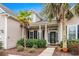Close-up of front porch and door with decorative glass, columns, and landscaping at 621 Elgin Ct., Myrtle Beach, SC 29579