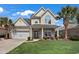 Charming two-story home featuring brick accents, a well-manicured lawn, and a welcoming front porch at 1002 Summers Pl., North Myrtle Beach, SC 29582
