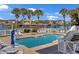 Community swimming pool surrounded by lounge chairs and palm trees with a nearby waterway at 1002 Summers Pl., North Myrtle Beach, SC 29582