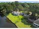 Aerial view of a beautiful waterfront property with lush lawn and mature trees at 1562 Hawthorn Dr., Pawleys Island, SC 29585