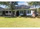 Beautiful brick home showcasing blue shutters, manicured lawn, and a charming covered porch at 1562 Hawthorn Dr., Pawleys Island, SC 29585