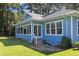 Exterior view of a blue home featuring a sunroom and a backyard deck at 1562 Hawthorn Dr., Pawleys Island, SC 29585
