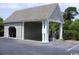 View of the garage with a gray shingle roof, white pillars, and a wash station, next to trees at 3762 Citation Way # 1016, Myrtle Beach, SC 29577
