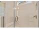 Close-up of an elegant glass-enclosed shower with tiled walls, bench, and sleek fixtures at 5028 Cambria Ct., Little River, SC 29566
