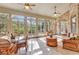Inviting sunroom features tile flooring, brick accents, and large windows overlooking the yard at 89 Gleneagle Ln., Pawleys Island, SC 29585