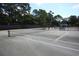 Well-maintained tennis court surrounded by tall trees, offering a private recreational space at 89 Gleneagle Ln., Pawleys Island, SC 29585