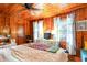 Bedroom with wood paneled walls, large bed, and bright windows at 4426 Old Kings Hwy., Murrells Inlet, SC 29576