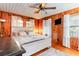 Warm bedroom features wood paneled walls, a ceiling fan, and a cozy white bedspread at 4426 Old Kings Hwy., Murrells Inlet, SC 29576
