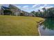 Expansive grassy backyard slopes gently toward a serene pond, offering a picturesque and tranquil outdoor space at 206 Mossy Stone Ct. # 1605, Murrells Inlet, SC 29576