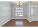 Empty dining room with hardwood floors, a window, decorative molding, and chandelier at 323 Trestle Way, Conway, SC 29526