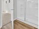 Modern bathroom with wood-look flooring, a white shower with glass doors, and a door leading to the bedroom at 389 Sun Colony Blvd., Longs, SC 29568