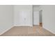 A bedroom features neutral carpet, white walls, large closet, adjacent room, and natural light at 389 Sun Colony Blvd., Longs, SC 29568